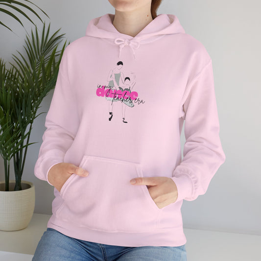 Person wearing a pink hoodie with a graphic design and text, standing against a plain background.