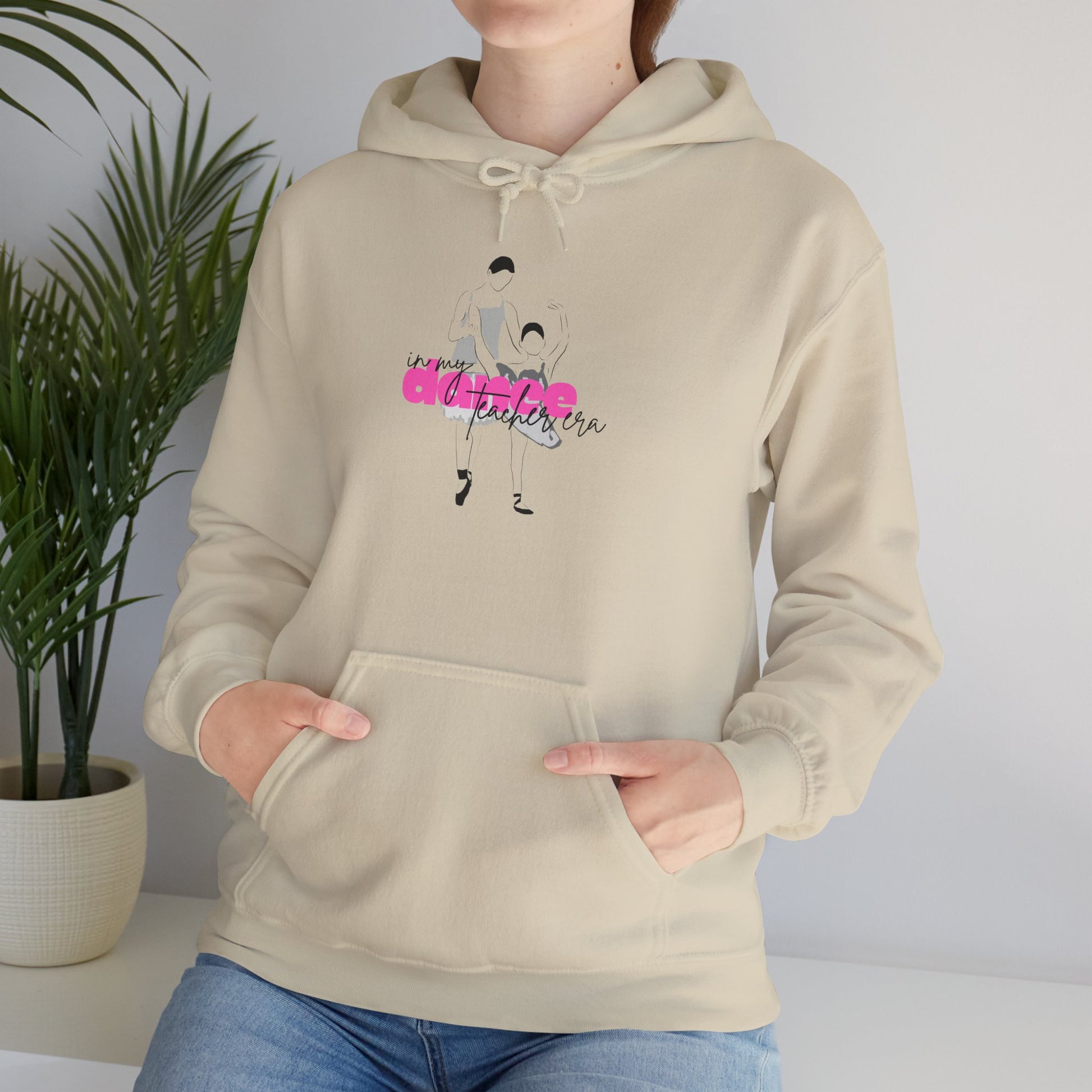 Person wearing a beige hoodie with a graphic design on a plain background