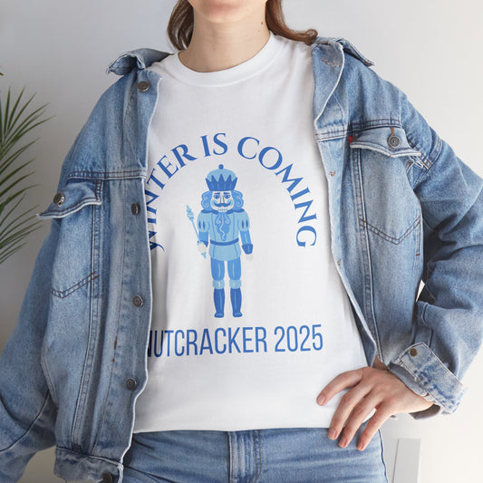 Person wearing a white t-shirt with a nutcracker design and text, paired with a denim jacket.