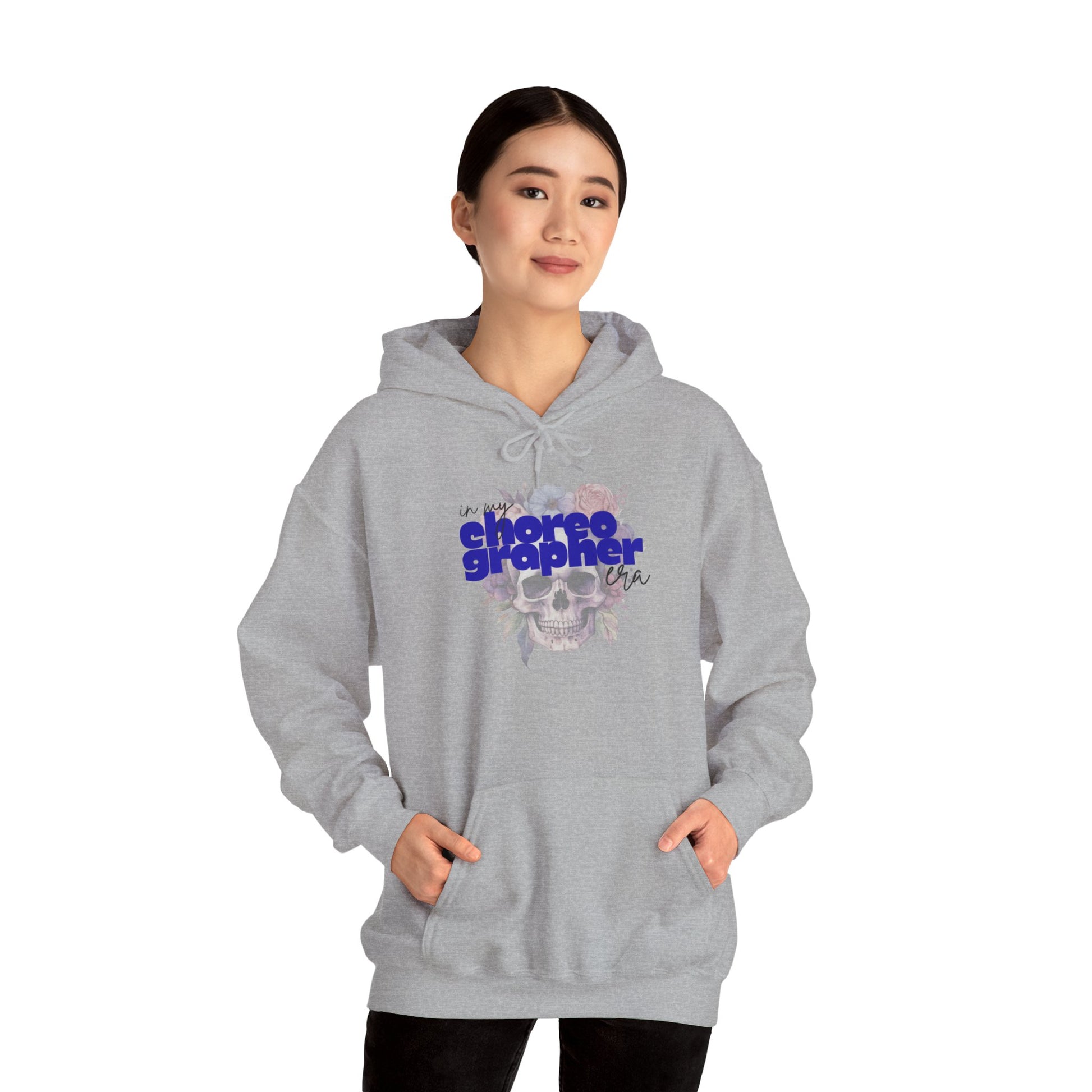 Person wearing a gray hoodie with 'choreographer' text and skull design on a white background