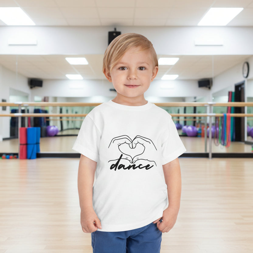 Child wearing a white t-shirt with 'dance' design in a dance studio