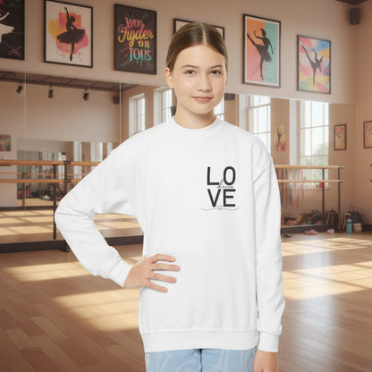 Person wearing a white sweatshirt with 'LOVE' printed on it in a dance studio