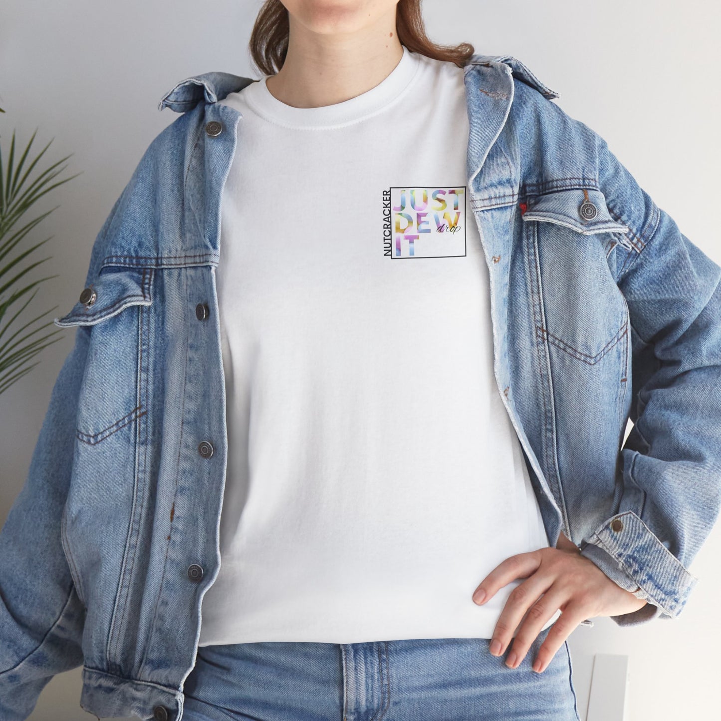 Person wearing a denim jacket over a white t-shirt with colorful text design.