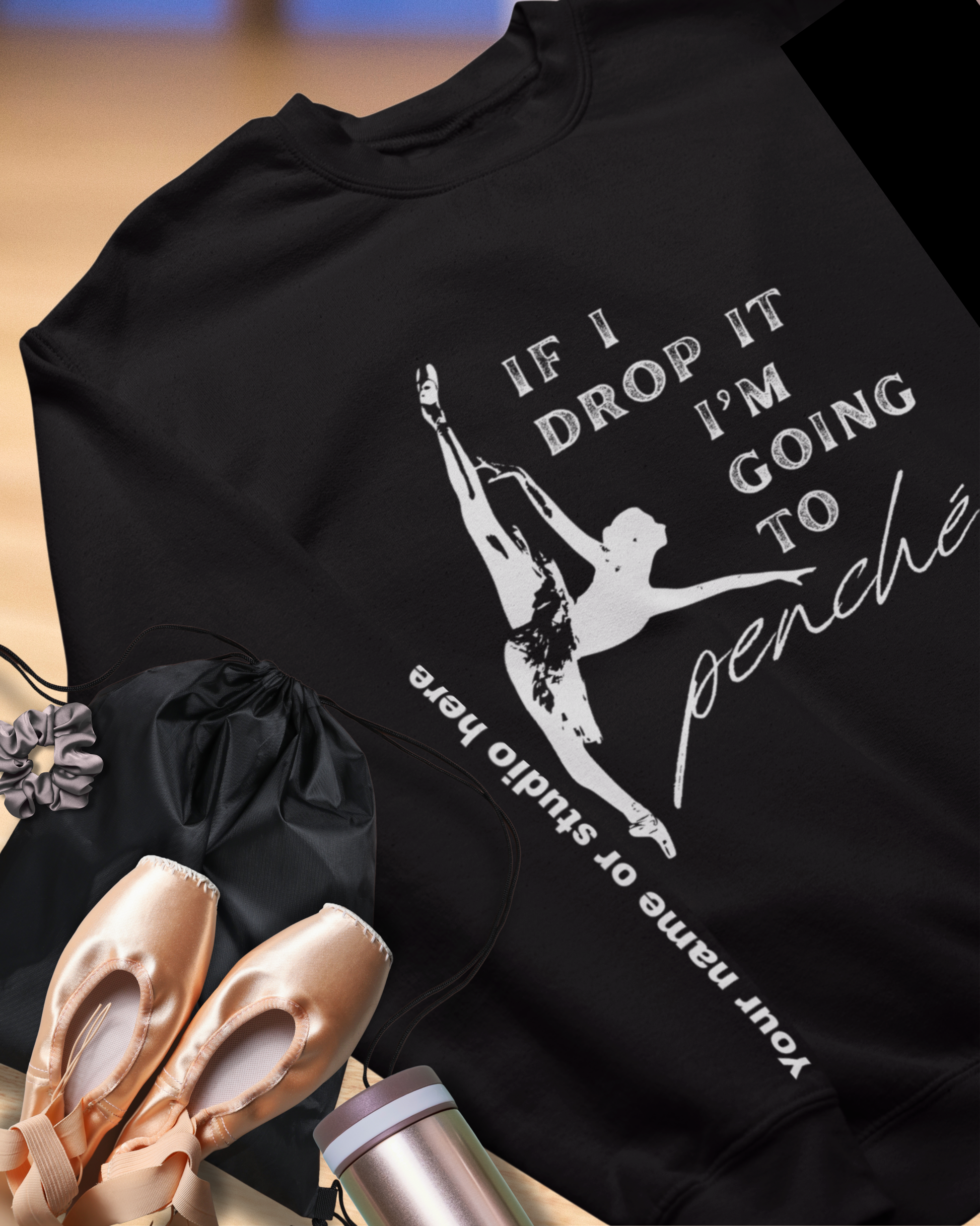 Black t-shirt with ballet-themed design and accessories on a wooden surface